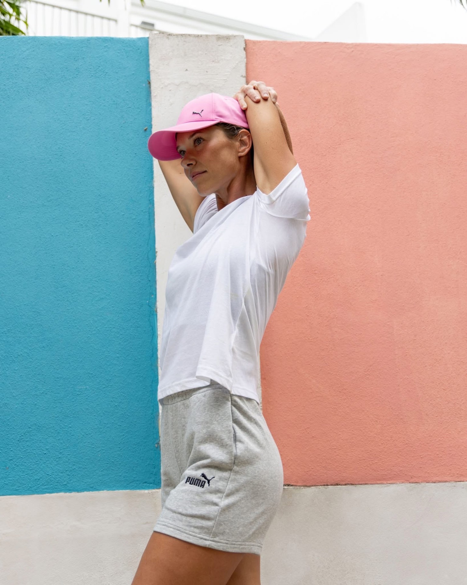 Personal trainer Manja Perko stretching against a colourful Caribbean wall in Saint-Martin